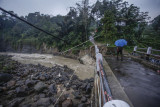 Warga melihat kondisi jembatan perbatasan Kecamatan Sukajaya dan Kecamatan Nanggung yang terputus di Desa Urug, Sukajaya, Kabupaten Bogor, Jawa Barat, Selasa (7/9/2021). Ambruknya jembatan yang disebabkan banjir bandang aliran Sungai Cidurian itu mengakibatkan akses jalan warga antar Kecamatan terputus. ANTARA FOTO/Yulius Satria Wijaya/rwa.