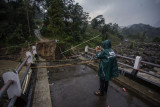 Warga melihat kondisi jembatan perbatasan Kecamatan Sukajaya dan Kecamatan Nanggung yang terputus di Desa Urug, Sukajaya, Kabupaten Bogor, Jawa Barat, Selasa (7/9/2021). Ambruknya jembatan yang disebabkan banjir bandang aliran Sungai Cidurian itu mengakibatkan akses jalan warga antar Kecamatan terputus. ANTARA FOTO/Yulius Satria Wijaya/rwa.