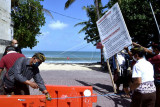 Petugas membuka akses masuk kawasan wisata Pantai Kuta di Badung, Bali, Rabu (8/9/2021). Gubernur Bali Wayan Koster mengizinkan Daya Tarik Wisata (DTW) alam, budaya, buatan, spiritual dan desa wisata di Pulau Dewata untuk mulai melakukan uji coba pembukaan kawasan bagi wisatawan dengan kapasitas pengunjung maksimal 50 persen, menerapkan protokol kesehatan yang ketat serta mengimplementasikan aplikasi PeduliLindungi. ANTARA FOTO/Fikri Yusuf/nym.