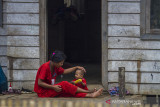 Warga Dayak Meratus duduk di depan rumahnya di lokasi perumahan Komunitas Adat Terpencil (KAT) di Dusun Danau Canting, Kabupaten Hulu Sungai tengah, Kalimantan Selatan, Kamis (9/9/2021). Kementerian Sosial Republik Indonesia akan menyerahkan bantuan kepada warga KAT di Desa Hinas Kiri seniliai Rp1,4 miliar lebih untuk peralatan sekolah, sarana air bersih, MCK, penghijauan, balai sosial dan penerangan lampu tenaga surya hemat energi yang akan di serahkan langsung oleh Menteri Sosial Republik Indonesia Tri Rismaharani yang dijadwalkan datang pada Selasa (14/9/2021). Foto Antaranews Kalsel/Bayu Pratama S.