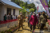 Menteri Sosial Tri Rismaharini (tengah) di dampingi Bupati Kabupaten Hulu Sungai Tengah Aulia Oktafiandi (kiri) berjalan di lokasi Perumahan KAT, Dusun Danau Canting, Kabupaten Hulu Sungai Tengah, Kalimantan Selatan, Selasa (14/9/2021). Dalam kunjungan kerja Menteri Sosial di Kalimantan Selatan selain menyerahkan bantuan sosial di pedalaman Pegunungan Meratus juga akan melakukan rangkaian kegiatan seperti Pemadanan Data Penerima Bantuan PKH dan BPNT, memberikan bantuan Asistensi Rehabilitasi Sosial (ATENSI) serta peninjauan lokasi banjir di Kabupaten Tanah Laut. Foto Antaranews Kalsel/Bayu Pratama S.