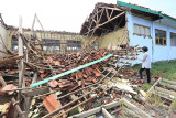Seorang siswa melihat reruntuhan bangunan laboratorium biologi yang ambruk di SMAN 1 Lelea, Indramayu, Jawa Barat, Rabu (15/9/2021). Dua ruangan laboratorium dan satu ruangan perpustakaan di sekolah itu ambruk akibat tidak kuat menahan guyuran hujan deras dan angin kencang. ANTARA FOTO/Dedhez Anggara/agr