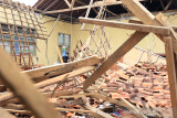 Seorang siswa melihat reruntuhan bangunan laboratorium biologi yang ambruk di SMAN 1 Lelea, Indramayu, Jawa Barat, Rabu (15/9/2021). Dua ruangan laboratorium dan satu ruangan perpustakaan di sekolah itu ambruk akibat tidak kuat menahan guyuran hujan deras dan angin kencang. ANTARA FOTO/Dedhez Anggara/agr