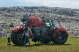 Sejumlah anak bermain di replika motor besar yang terbuat dari bahan bekas di tempat pembuangan akhir (TPA) sampah Pakusari, Jember, Jawa Timur, Sabtu (18/9/2021). Pemerintah Kabupaten Jember bersama aktivis lingkungan berkampanye memilih dan memilah sampah sebelum dibuang ke TPA sampah bertepatan dengan peringatan Hari World Cleanup Day 2021 pada 18 September, dengan mengolahnya menjadi replika motor besar, dinosaurus, dan rumah botol. ANTARA FOTO/Seno/nym.