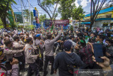 Sejumlah mahasiswa yang tergabung dalam HMI Cabang Banjarmasin terlibat saling dorong dengan petugas kepolisian saat melakukan aksi unjuk rasa di kawasan Jalan Lambung Mangkurat, Banjarmasin, Kalimantan Selatan, Senin (20/9/2021). Dalam aksinya HMI cabang Banjarmasin menyuarakan tiga tuntutan yakni masyarakat merasa terbatasi dengan adanya puskesmas yang memprioritaskan domisili, adanya isu tentang ketakutan warga terhadap vaksin yang beredar dan antusias tinggi namun tidak diiringi dengan ketersediaan vaksinasi. Foto Antaranews Kalsel/Bayu Pratama S.