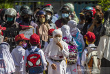 Orang tua siswa menjemput anaknya usai mengikuti Pembelajaran Tatap Muka (PTM) di SD Negeri Karang Mekar 5, Banjarmasin, Kalimantan Selatan, Senin (20/9/2021). Pemerintah Kota Banjarmasin melalui Dinas Pendidikan Kota Banjarmasin kembali melaksanakan Pembelajaran Tatap Muka (PTM) untuk semua jenjang pendidikan yakni Pendidikan Anak Usia Dini (PAUD), Sekolah Dasar (SD) dan Sekolah Menengah Pertama (SMP) setelah mendapat izin atau rekomendasi dari Satgas COVID-19 Banjarmasin Serta mempertimbangkan Surat Keputusan Bersama (SKB) empat Menteri dengan penerapan disiplin protokol kesehatan yang ketat. Foto Antaranews Kalsel/Bayu Pratama S.