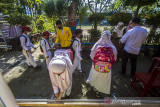 Sejumlah siswa mencuci tangan dan diukur suhu tubuh sebelum masuk kelas di SD Negeri Karang Mekar 5, Banjarmasin, Kalimantan Selatan, Senin (20/9/2021). Pemerintah Kota Banjarmasin melalui Dinas Pendidikan Kota Banjarmasin kembali melaksanakan Pembelajaran Tatap Muka (PTM) untuk semua jenjang pendidikan yakni Pendidikan Anak Usia Dini (PAUD), Sekolah Dasar (SD) dan Sekolah Menengah Pertama (SMP) setelah mendapat izin atau rekomendasi dari Satgas COVID-19 Banjarmasin Serta mempertimbangkan Surat Keputusan Bersama (SKB) empat Menteri dengan penerapan disiplin protokol kesehatan yang ketat. Foto Antaranews Kalsel/Bayu Pratama S.