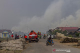 Sejumlah relawan berupaya memadamkan kebakaran lahan yang mendekati rumah warga di Kecamatan Liang Anggang, Banjarbaru, Kalimantan Selatan, Selasa (21/9/2021). Kencangnya angin di lokasi yang terbakar membuat api dengan cepat membakar lahan yang diperkirakan mencapai puluhan hektare hingga kini BPBD Kota Banjarbaru dibantu relawan pemadam kebakaran Kota Banjarmasin berupaya memadamkan api yang mendekati permukiman penduduk di daerah setempat. Foto Antaranews Kalsel/Bayu Pratama S.