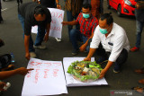 Pendemo yang tergabung dalam Jaringan Aliansi Aktivis Malang Raya (JAASMARA) membawa poster dan tumpeng saat berunjuk rasa di depan Balai Kota Malang, Jawa Timur, Selasa (21/9/2021). Dalam aksinya mereka memprotes kegiatan bersepeda Wali Kota Malang  bersama pejabat daerah setempat yang diduga melanggar aturan Pemberlakuan Pembatasan Kegiatan Masyarakat (PPKM) Level III karena memasuki kawasan pantai yang masih ditutup.  Antara Jatim/Ari Bowo Sucipto/zk