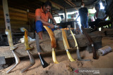 PERAJIN RENCONG TERDAMPAK PANDEMI. Perajin menyelesaikan pembuatan senjata tradisional Rencong Aceh di rumah produksi pandai besi, desa Baet Masjid, kecamatan Suka Makmur, Kabupaten Aceh Besar, Aceh, Rabu (22/9/2021). Menurut perajin, selama pandemi COVID-19 permintaan senjata tradisional Rencong Aceh menurun dan hanya di produksi jika ada permintaan masyarakat sebagai cenderamata souvenir dengan harga penjualan Rp 150.000 hingga Rp450.000 per rencong menurut jenis,ukuran serta bahan bakunya. ANTARA FOTO/Ampelsa.