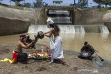 Seniman yang tergabung dalam Teater Jero melakukan prosesi Tradisi Ruwatan Sungai Cilamaya di Bendungan Barugbug, Jatisari, Karawang, Jawa Barat, Rabu (22/9/2021). Kegiatan tersebut diselenggarakan oleh Forum Daerah Sungai (Fordas) Cilamaya Berbunga sebagai ungkapan rasa syukur dan keberkahan yang diberikan Tuhan atas air yang mengalir dari sungai Cilamaya melalui Kabupaten Purwakarta, Subang dan Karawang untuk kehidupan masyarakat. ANTARA FOTO/M Ibnu Chazar/agr
