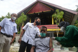 VAKSINASI DOOR TO DOOR WARGA DI ACEH BESAR. Petugas kesehatan Puskesmas menyuntikkan vaksin COVID-19 kepada warga saat berlangsung vaksinasi door to door di desa Lamneuhen, Kecamatan Kuta Baro, Kabupaten Aceh Besar, Aceh, Rabu (22/9/2021). Vaksinasi door to door yang mulai digelar di sejumlah desa di Aceh itu, merupakan realisasi dari arahan  Presiden RI Joko Widodo saat berkunjung di daerah itu pada 16 September 2021  dalam upaya memberikan pelayanan langsung kepada masyarakat guna  percepatan vaksinasi dalam penanganan COVID-19. ANTARA FOTO/Ampelsa.