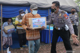 Sejumlah tunawisma menerima bingkisan bantuan sembako sebelum vaksinasi COVID-19 di Kota Kediri, Jawa Timur, Kamis (23/9/2021). Polres Kediri Kota menyelenggarakan vaksinasi COVID-19 sekaligus penyerahan bantuan sembako kepada 64 orang tunawisma guna memperingati Hari Lalu Lintas Bhayangkara ke-66. Antara Jatim/Prasetia Fauzani/zk