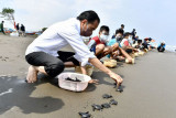 Presiden Joko Widodo melepas tukik di Pantai Kemiren, Desa Griya Tegalsari, Kelurahan Tegal Kamulyan, Cilacap Selatan, Cilacap, Jawa Tengah (23/9/2021). ANTARA FOTO/Setpres-Agus Suparto/foc.
