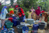 Petugas gabungan dari Palang Merah Indonesia (PMI) mengisi air bersih saat pendistribusian air secara gratis di Desa Kertasari, Pangkalan, Karawang, Jawa Barat, Sabtu (25/9/2021). PMI bersama Tagana mendistribusikan sebanyak 31 ribu liter air bersih untuk warga yang mengalami kesulitan air bersih sebanyak 595 Kartu Keluarga (KK). ANTARA FOTO/M Ibnu Chazar/agr