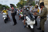 Petugas gabungan memberikan informasi kepada sejumlah warga saat hari pertama sosialisasi penerapan sistem ganjil genap dalam Pemberlakuan Pembatasan Kegiatan Masyarakat (PPKM) level 3 di pintu masuk Pantai Sanur, Denpasar, Bali, Sabtu (25/9/2021). Petugas gabungan dari Dinas Perhubungan Provinsi Bali, Polresta Denpasar dan Satpol PP melakukan sosialisasi terkait penerapan ganjil genap tersebut untuk membatasi jumlah pengunjung maksimal 50 persen di kawasan objek wisata itu. ANTARA FOTO/Nyoman Hendra Wibowo/nym.