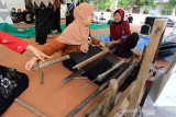 Peserta mencoba alat tenun Gedogan tradisional dalam acara Refleksi Hari Tenun di Gedung kesenian Indramayu, Jawa Barat, Minggu (26/9/2021). Kegiatan yang digelar Tenun Gedogan Fest itu untuk mengenalkan tenun tradisional kepada generasi muda sekaligus sebagai upaya melestarikan tenun Gedogan yang terancam punah. ANTARA FOTO/Dedhez Anggara/agr