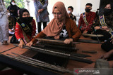 Peserta mencoba alat tenun Gedogan tradisional dalam acara Refleksi Hari Tenun di Gedung kesenian Indramayu, Jawa Barat, Minggu (26/9/2021). Kegiatan yang digelar Tenun Gedogan Fest itu untuk mengenalkan tenun tradisional kepada generasi muda sekaligus sebagai upaya melestarikan tenun Gedogan yang terancam punah. ANTARA FOTO/Dedhez Anggara/agr