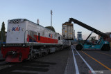 Operator alat berat memindahkan kontainer dari truk trailer ke kereta api logistik di Terminal Petikemas Surabaya (TPS), Surabaya, Jawa Timur, Selasa (28/9/2021). Terminal Petikemas Surabaya (TPS) telah mengaktifkan kembali jalur angkutan logistik menggunakan kereta api tersebut untuk memperlancar arus barang dari dan ke Pelabuhan Tanjung Perak Surabaya. Antara Jatim/Didik Suhartono/zk.