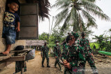 PANGDAM IM TINJAU TMMD DAERAH BEKAS ZONA MERAH KONFLIK ACEH. Pangdam Iskandar Muda (IM), Mayjen TNI Achmad Marzuki melihat seorang anak yang berdiri di jendela rumahnya saat meninjau langsung pembangunan Rumah Tidak Layak Huni (RTLH) program TMMD ke-112 di Desa Cot Trieng, Muara Satu, Lhokseumawe, Aceh, Rabu (29/9/2021). Program TMMD Ke-112 Kodam IM yang dilaksanakan di Lhokseumawea, Aceh Timur dan Subulsaalam itu bertujuan membantu Pemerintah dalam meningkatkan pembangunan dan Kesejahteraan masyarakat di daerah tertinggal/miskin dan pedesaan bekas zona merah konflik Aceh. ANTARA FOTO/ Rahmad.ANTARA FOTO/RAHMAD