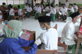 Vaksinator menyuntikkan vaksin COVID-19 kepada santri saat vaksinasi massal di Pesantren Al-Ikhlas, Tanjungpura, Karawang, Jawa Barat, Kamis (30/9/2021). Pemerintah Provinsi Jawa Barat menargetkan sebanyak tiga juta santri menerima vaksin COVID-19 dari jumlah total 12 ribu pesantren di Jawa Barat. ANTARA FOTO/M Ibnu Chazar/agr