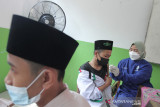 Vaksinator menyuntikkan vaksin COVID-19 kepada santri saat vaksinasi massal di Pesantren Al-Ikhlas, Tanjungpura, Karawang, Jawa Barat, Kamis (30/9/2021). Pemerintah Provinsi Jawa Barat menargetkan sebanyak tiga juta santri menerima vaksin COVID-19 dari jumlah total 12 ribu pesantren di Jawa Barat. ANTARA FOTO/M Ibnu Chazar/agr