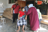 Petugas medis memeriksa kondisi kesehatan penyandang disabilitas sebelum vaksinasi COVID-19 di Desa Srikaton, Kediri, Jawa Timur, Jumat (1/10/2021). Vaksinasi COVID-19 dosis ke dua secara jemput bola tersebut guna memberikan kemudahan layanan kepada penyandang disabilitas yang kesulitan mendatangi lokasi vaksinasi. Antara Jatim/Prasetia Fauzani/zk.