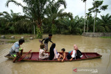 BANJIR TERJANG ACEH UTARA. Warga menggunakan perahu keluar dari kepungan banjir di Desa Hagu, Kecamatan Matang Kuli, Aceh Utara, Aceh, Jumat (1/10/2021). Banjir yang disebabkan tingginya intensitas hujan hingga sejumlah tanggul sungai jebol itu merendam tujuh kecamatan di Aceh Utara dan dua kecamatan Kota Lhokseumawe dengan ketinggian air 1-2,5 meter. ANTARA FOTO/Rahmad