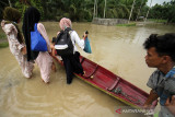 BANJIR TERJANG ACEH UTARA. Warga menggunakan perahu keluar dari kepungan banjir di Desa Hagu, Kecamatan Matang Kuli, Aceh Utara, Aceh, Jumat (1/10/2021). Banjir yang disebabkan tingginya intensitas hujan hingga sejumlah tanggul sungai jebol itu merendam tujuh kecamatan di Aceh Utara dan dua kecamatan Kota Lhokseumawe dengan ketinggian air 1-2,5 meter. ANTARA FOTO/Rahmad