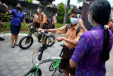 Guru memeriksa suhu tubuh siswa sebelum memasuki kelas saat hari pertama pembelajaran tatap muka (PTM) terbatas di SMP Negeri 1 Kuta, Badung, Bali, Jumat (1/10/2021). Sekolah di wilayah Kabupaten Badung mulai menyelenggarakan PTM terbatas dengan menerapkan protokol kesehatan secara ketat untuk mencegah penyebaran pandemi COVID-19 serta mengatur jadwal kehadiran siswa yang dibagi menjadi sejumlah sesi untuk membatasi kapasitas ruangan kelas maksimal 50 persen dengan durasi pembelajaran maksimal dua jam. ANTARA FOTO/Fikri Yusuf/nym.