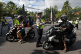 Polisi menghentikan pengendara sepeda motor dengan plat nomor ganjil saat penerapan ganjil genap dalam Pemberlakuan Pembatasan Kegiatan Masyarakat (PPKM) level 3 di pintu masuk Pantai Bangsal Sanur, Denpasar, Bali, Sabtu (2/10/2021). Pemberlakuan ganjil genap digelar di tujuh titik pintu masuk objek wisata di wilayah Sanur untuk mengantisipasi kerumunan pada libur akhir pekan sebagai upaya menekan penyebaran COVID-19 dan dikecualikan bagi masyarakat yang menyeberang ke Pulau Nusa Penida atau bekerja di kawasan itu. ANTARA FOTO/Nyoman Hendra Wibowo/nym.