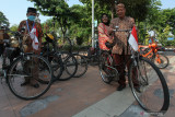 Sejumlah anggota komunitas sepeda tua Senopati dengan berpakaian batik bersiap mengayuh sepedanya di Jalan Darmo, Surabaya, Jawa Timur, Minggu (3/10/2021). Kegiatan bersepeda bersama menyusuri jalan dengan mengenakan busana batik itu dalam rangka menyemarakkan Hari Batik Nasional. Antara Jatim/Didik Suhartono/zk.