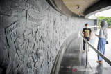 Seorang pemandu memberikan penjelasan sebuah relief yang menggambarkan tragedi G30SPKI kepada seorang pengunjung di museum Monumen Perjuangan Rakyat di Bandung, Jawa Barat, Jumat (1/10/2021). Bertepatan dengan Hari Kesaktian Pancasila, pengelola Museum Monumen Perjuangan Rakyat membatasi kunjungan warga dengan hanya maksimal tujuh orang pengunjung guna mencegah penyebaran COVID-19. ANTARA FOTO/Raisan Al Farisi/agr