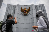 Seorang pemandu memberikan penjelasan lambang Garuda kepada seorang pengunjung di museum Monumen Perjuangan Rakyat di Bandung, Jawa Barat, Jumat (1/10/2021). Bertepatan dengan Hari Kesaktian Pancasila, pengelola Museum Monumen Perjuangan Rakyat membatasi kunjungan warga dengan hanya maksimal tujuh orang pengunjung guna mencegah penyebaran COVID-19. ANTARA FOTO/Raisan Al Farisi/agr
