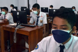 Siswa kelas VIII mengerjakan soal saat mengikuti Asesmen Nasional Berbasis Komputer (ANBK) 2021 di SMP Negeri 10 Denpasar, Bali, Senin (4/10/2021). ANBK yang diikuti 3.363 siswa dari 80 SMP negeri maupun swasta di Denpasar tersebut dilaksanakan dua gelombang, yakni gelombang pertama bagi sekolah yang memiliki fasilitas komputer lengkap digelar pada 4-5 Oktober 2021 dan untuk gelombang kedua bagi sekolah yang menumpang di sekolah yang memiliki fasilitas komputer lengkap digelar pada 6-7 Oktober 2021 dengan menerapkan protokol kesehatan COVID-19 yang ketat. ANTARA FOTO/Nyoman Hendra Wibowo/nym.