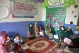 PERINGATAN HARI CEREBRAL PALSY SEDUNIA DENGAN PROKES COVID-19. Orang tua mendapingi anaknya mengenakan masker saat pemberian hadiah lomba kreativitas menggambar dan mewarnai di Yayasan Sahabat Difabel, desa Meunasah Papan, Kabupaten Aceh Besar, Aceh, Rabu (6/10/2021).  Lomba kreativitas anak dalam rangka memperingati hari Cerebral Palsy Sedunia  digelar tetap menerapkan protokol kesehatan guna mencegah penyeberan COVID-19. ANTARA FOTO/Ampelsa