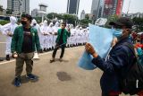 Mahasiswa melakukan aksi simbolik di kawasan Monas, Jakarta, Rabu (6/10/2021). Aksi yang diikuti oleh aliansi BEM seluruh Indonesia ini untuk memperingati satu tahun perjalanan Omnibus Law. ANTARA FOTO/Rivan Awal Lingga/hp.