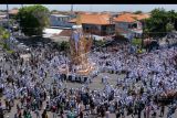 Ratusan warga mengiringi arak-arakan bade atau menara usungan jenazah Ida Pedanda Nabe Gede Dwija Ngenjung saat upacara Ngaben di kawasan Sanur, Denpasar, Bali, Jumat (8/10/2021). Upacara Ngaben mendiang pemuka agama Hindu sekaligus tokoh pariwisata tersebut merupakan upacara berskala besar pertama yang digelar selama masa pandemi COVID-19 setelah turunnya level PPKM di Bali dari level 4 berubah menjadi level 3. ANTARA FOTO/Nyoman Hendra Wibowo/nym.