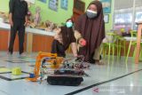 SISWA MTsN CIPTAKAN ROBOT MEDIS COVID-19. Siswa mengenakan masker mengoperasikan mobil robot saat diujicobakan di Sekolah Madrasyah Tsanawiyah Negeri-1 (MTsN) Banda Aceh, Aceh, Jumat (8/10/2021). Pembuatan mobil robot yang diperuntukkan membantu tugas tenaga medis dalam penanganan COVID-19 itu merupakan persiapan untuk mengikuti kompetisi Robitik Madrasyah Tingkat Nasional tahun 2021 dengan tema Robots for Global Pandemic yang dijadwalkan berlangsung 16-17 Oktober 2021 di Kota Tangerang, Provinsi Banten. ANTARA FOTO/Ampelsa.