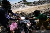 PEMBAGIAN MAKANAN BAGI PEMULUNG. Warga membagikan nasi kotak kepada pemulung di tempat pembuangan akhir (TPA) Alue Lim Lhokseumawe, Aceh, Jumat (8/10/2021). Pembagian makanan gratis tersebut untuk membantu meringankan beban ekonomi masyarakat sebagai bentuk kepedulian terhadap sesama di tengah pandemi COVID-19. ANTARA/Rahmad