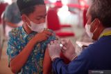 Petugas kesehatan menyuntikan vaksin COVID-19 kepada santri di kompleks Pesantren Matholiúl Anwar, Lamongan, Jawa Timur,  Jumat (8/10/2021). Otoritas Jasa Keuangan bersama PT. Bursa Efek Indonesia (BEI), PT. Kliring Penjaminan Efek Indonesia (KPEI), dan PT. Kustodian Sentral Efek Indonesia (KSEI) menyelenggarakan rangkaian kegiatan sosial dan vaksinasi yang bertujuan untuk membantu masyarakat yang membutuhkan bantuan di tengah kondisi pandemi dan juga dalam rangka peringatan 44 tahun Diaktifkannya Kembali Pasar Modal Indonesia. Antara Jatim/Umarul Faruq/zk.