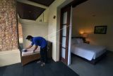 Pekerja membersihkan kamar yang akan digunakan sebagai tempat karantina bagi wisatawan mancanegara di Hotel Griya Santrian, Sanur, Denpasar, Bali, Senin (11/10/2021). Kantor Kesehatan Pelabuhan (KKP) Kelas I Denpasar menyiapkan 35 hotel untuk karantina yang telah lolos verifikasi dan penambahan sebanyak 20 hotel yang masih proses verifikasi sebagai tempat karantina untuk mengantisipasi lonjakan kedatangan wisatawan mancanegara yang mengunjungi Pulau Dewata menjelang dibukanya pariwisata Bali pada 14 Oktober 2021 mendatang. ANTARA FOTO/Nyoman Hendra Wibowo/nym.