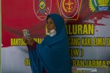 Warga menunjukkan bantuan tunai PKL dan Warung (BTPKLW) di Makodim 1007 Banjarmasin, Kalimantan Selatan, Rabu (13/10/2021). Mabes TNI melalui Kodim 1007 Banjarmasin menyalurkan BPTPKLW yang merupakan program pemerintah kepada 3.200 pedagang kaki lima dan pemilik warung sebesar Rp1,2 juta untuk setiap penerima guna membantu mereka bertahan dan memulihkan usaha akibat terdampak pandemi COVID-19. Foto Antaranews Kalsel/Bayu Pratama S.