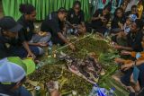 Atlet sepakbola putri Papua bersama warga menggelar pesta adat bakar batu di Kabupaten Merauke, Papua, Rabu (13/10/2021). Pesta bakar batu tersebut sebagai bentuk ucapan syukur atas keberhasilan tim sepak bola putri Papua meraih medali emas dalam ajang PON Papua. ANTARA FOTO/Galih Pradipta/nym.