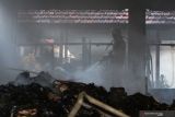 Petugas Dinas Pemadam Kebakaran Kota Surabaya melakukan pembasahan ruangan yang terbakar di komplek Kantor Kementerian Pekerjaan Umum dan Perumahan Rakyat Jalan Gayung Kebonsari No 50, Surabaya, Jawa Timur, Rabu (13/10/2021). Sebanyak 14 unit kendaraan pemadam kebakaran dikerahkan untuk memadamkan api yang membakar satu ruang kantor dan sejumlah ruangan penyimpanan dokumen tersebut. Antara Jatim/Didik Suhartono/zk.