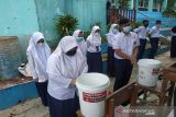 Siswa SMP salah satu sekolah di Sukabumi sedang mempratikan cara mencuci tangan memakai sabun yang baik dan benar. (Foto Antara/HO/PMI/IFRC).