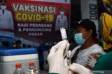 Petugas kesehatan menyiapkan vaksin COVID-19 sebelum disuntikkan kepada warga saat vaksinasi massal bagi pedagang dan pengunjung di Pasar Besar Kota Madiun, Jawa Timur, Jumat (15/10/2021). Pemkot Madiun menggelar vaksinasi massal di lokasi yang banyak dikunjungi warga tersebut guna mengejar capaian 100 persen vaksinasi COVID-19 di daerah yang saat ini vaksinasinya mencapai 93,12 persen dosis 1 dan 57,68 persen dosis 2 dari total sasaran 197.000 orang. Antara Jatim/Siswowidodo/zk.