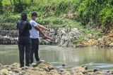 Sejumlah warga menyaksikan para petugas tim inafis melakukan olah tempat kejadian perkara siswa yang tewas tenggelam di Sungai Cileueur, Desa Utama, Kabupaten Ciamis, Jawa Barat, Sabtu (16/10/2021). Polres Ciamis belum memberikan keterangan resmi terkait peristiwa 11 siswa MTs Harapan Baru yang tewas dalam kegiatan pramuka susur sungai. ANTARA FOTO/Adeng Bustomi/hp.