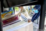 Warga membaca buku koleksi motor perpustakaan keliling di Desa Sugihwaras, Sidoarjo, Jawa Timur, Senin (18/10/2021). Layanan perpustakaan keliling tersebut mulai beroperasi kembali berkeliling ke sejumlah desa dengan menerapkan protokol kesehatan dengan tujuan untuk meningkatkan budaya membaca masyarakat. Antara Jatim/Umarul Faruq/zk