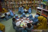 PERINGATAN HARI PERPUSTAKAAN SEKOLAH INTERNASIONAL DENGAN PROKES. Guru memperkenalkan berbagai buku pelajaran kepada murid dan dilanjutkan dengan kegiatan mewarnai di perpustakaan sekolah  TK Rumah Baca  Anak Nanggroe (Ruman) Banda Aceh, Aceh, Senin (18/10/2021). Kegiatan murid tersebut dalam rangka memperingati Hari Perpustakaan Sekolah Internasional dengan tujuan membangun kesadaran budaya literasi kepada pelajar, termasuk anak usia dini.ANTARA FOTO/Ampelsa.